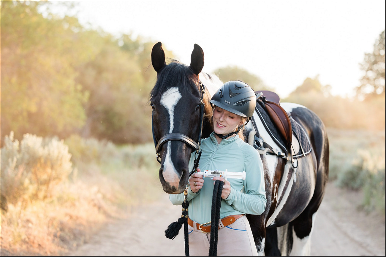 An English rider offers her horse IsoBalance—Redmond's isotonic electrolyte paste.